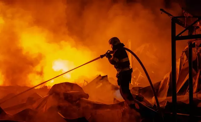 Firefighters put out a fire after Russian missiles hit a warehouse in Kyiv, Ukraine, Wednesday, Aug. 5, 2026. (AP Photo/Dan Bashakov)