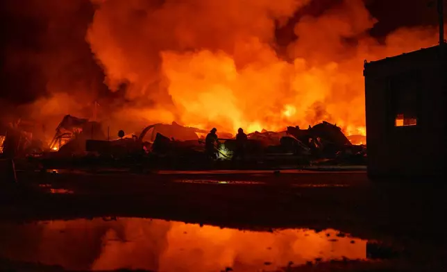 Firefighters put out a fire after Russian missiles hit a warehouse in Kyiv, Ukraine, Wednesday, Aug. 5, 2026. (AP Photo/Dan Bashakov)
