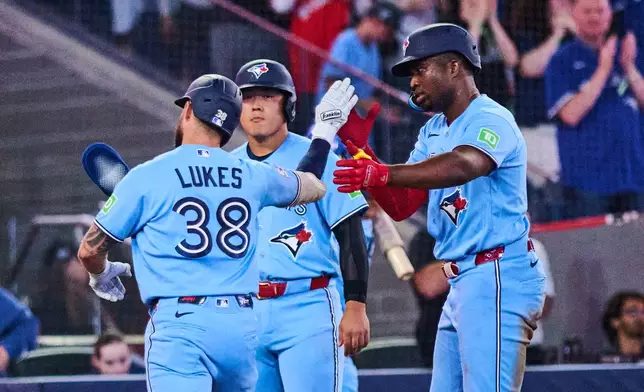 Toronto Blue Jays' Nathan Lukes, left, celebrates his three-run home run against the Kansas City Royals with with Kazuma Okamoto, center, and Jesus Sanchez, right, during the fourth inning of a baseball game in Toronto, Wednesday, Aug. 26, 2026. (Sammy Kogan/The Canadian Press via AP)