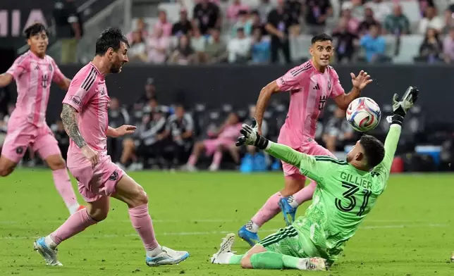 Inter Miami forward Lionel Messi, left, scores his third goal of the match, his side's fifth, past CF Montreal goalkeeper Thomas Gillier (31) during the second half of an MLS soccer match, Saturday, Aug. 29, 2026, in Miami. (AP Photo/Rebecca Blackwell)