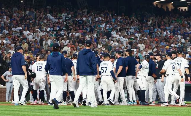 Seattle Mariners and Detroit Tigers members rush the mound in the eighth inning of a baseball game on Wednesday, Aug. 5, 2026, in Seattle. (AP Photo/Kevin Ng)