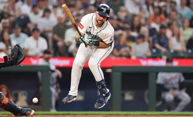 Seattle Mariners' Cal Raleigh is hit by a pitch from Detroit Tigers pitcher Enmanuel De Jesus in the seventh inning of a baseball game Wednesday, Aug. 5, 2026, in Seattle. (AP Photo/Kevin Ng)