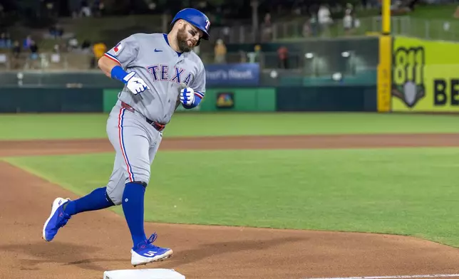 Texas Rangers' Jake Burger runs the bases after hitting a three-run home run during the sixth inning of a baseball game against the Athletics, Friday, Aug. 14, 2026, in West Sacramento, Calif. (AP Photo/Sara Nevis)
