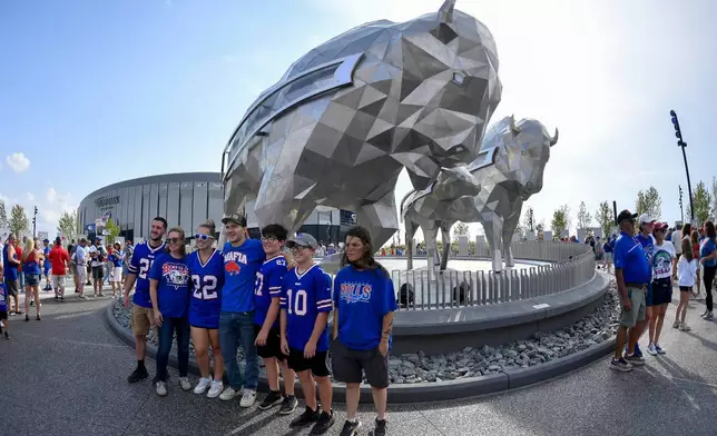 Buffalo Bills fans pose for photos outside of Highmark Stadium before practice at the team's NFL football training camp Saturday, Aug. 8, 2026, in Orchard Park, N.Y. (AP Photo/Adrian Kraus)
