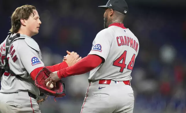 Boston Red Sox catcher Adley Rutschman, left, shakes hands relief pitcher Aroldis Chapman (44) after defeating the Miami Marlins, during the of a baseball game, Monday, Aug. 24, 2026, in Miami. (AP Photo/Lynne Sladky)