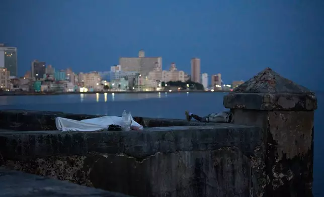 People sleep on the Malecón seawall to escape the heat of their homes during a power outage in Havana, Cuba, Wednesday, Aug. 5, 2026. (AP Photo/Ramon Espinosa)