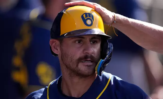 Milwaukee Brewers' Joey Ortiz is congratulated by teammates in the dugout after hitting a two-run home run during the second inning of a baseball game against the Los Angeles Dodgers, Saturday, Aug. 15, 2026, in Los Angeles. (AP Photo/Mark J. Terrill)