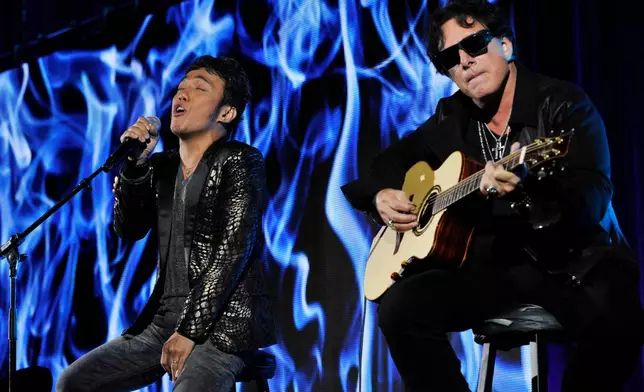 FILE - Arnel Pineda, left, and Neal Schon, of the rock band Journey, perform after a panel discussion on the Independent Lens documentary "Don't Stop Believin': Everyman's Journey," at the PBS Summer 2013 TCA press tour in Beverly Hills, Calif., on Aug. 6, 2013. (Photo by Chris Pizzello/Invision/AP, File)