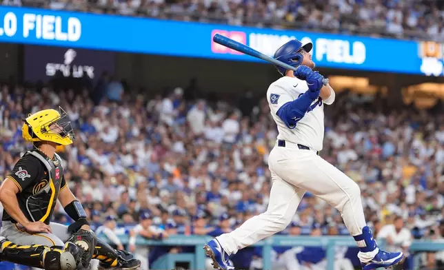 Los Angeles Dodgers' Max Muncy, right, hits a two-run home run as Pittsburgh Pirates catcher Rafael Flores Jr. watches during the first inning of a baseball game Friday, Aug. 21, 2026, in Los Angeles. (AP Photo/Mark J. Terrill)