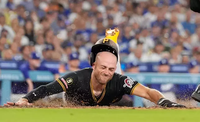 Pittsburgh Pirates' Brandon Lowe scores on a single by Nick Gonzales during the third inning of a baseball game against the Los Angeles Dodgers, Friday, Aug. 21, 2026, in Los Angeles. (AP Photo/Mark J. Terrill)