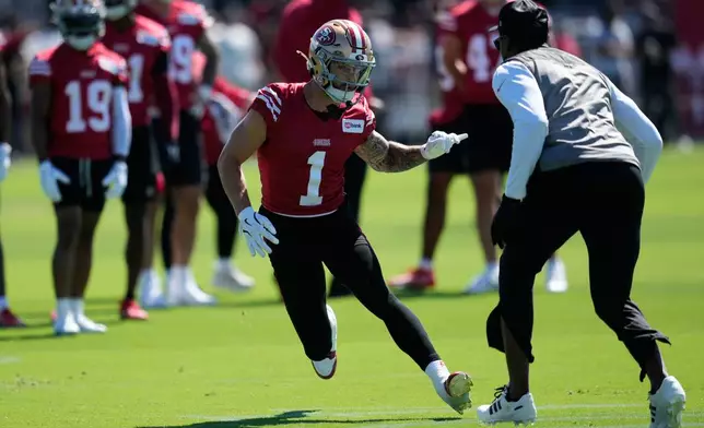 San Francisco 49ers wide receiver Ricky Pearsall (1) runs a drill against wide receivers coach Leonard Hankerson during the NFL football team's training camp Monday, July 27, 2026, in Santa Clara, Calif. (AP Photo/Jeff Chiu)