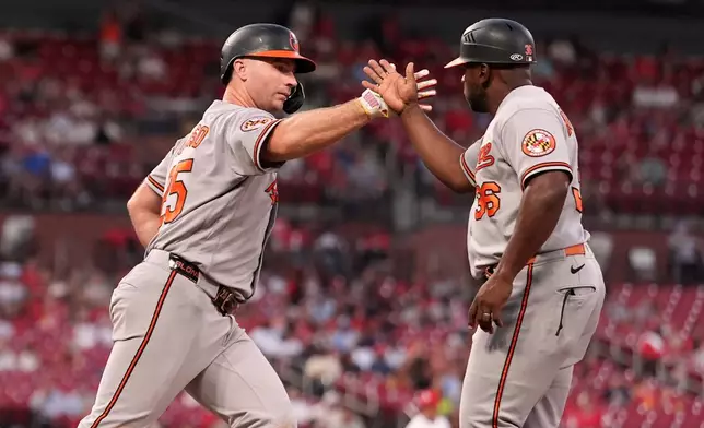 Baltimore Orioles' Pete Alonso, left, is congratulated by first base coach Jason Bourgeois after hitting a three-run home run during the third inning of a baseball game against the St. Louis Cardinals Tuesday, Aug. 25, 2026, in St. Louis. (AP Photo/Jeff Roberson)
