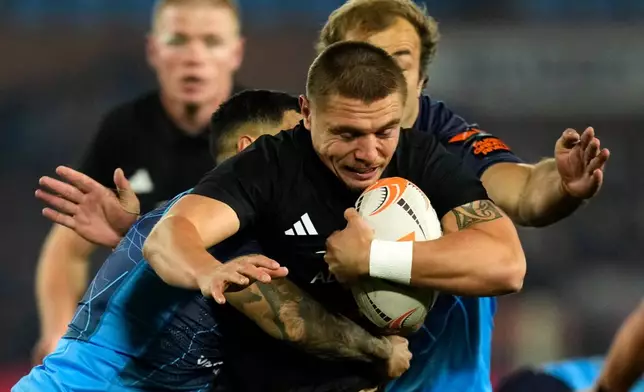 New Zealand's Cortez Ratima, front, is tackled by Bulls' Embrose Papier during a rugby match between Bulls and New Zealand, in Pretoria, South Africa, Saturday, Aug. 15, 2026. (AP Photo/Themba Hadebe)