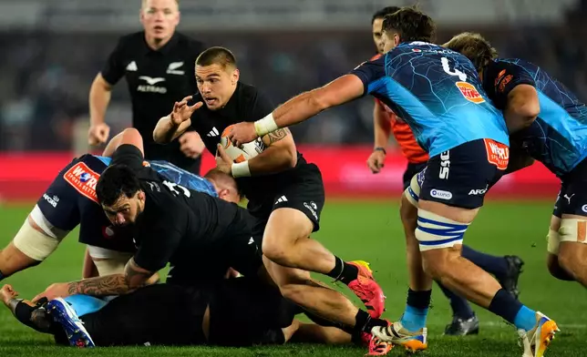 New Zealand's Cortez Ratima, left, is challenged by Bulls' Ruan Vermaak during a rugby match between Bulls and New Zealand, in Pretoria, South Africa, Saturday, Aug. 15, 2026. (AP Photo/Themba Hadebe)
