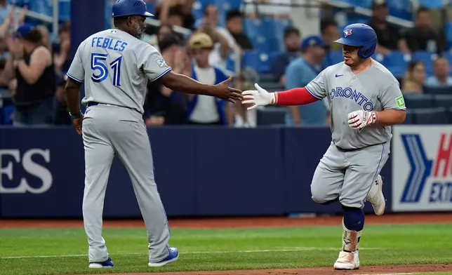 Toronto Blue Jays' Alejandro Kirk celebrates his home run off Tampa Bay Rays pitcher Drew Rasmussen with third base coach Carlos Febles (51) during the fourth inning of a baseball game Wednesday, Aug. 19, 2026, in St. Petersburg, Fla. (AP Photo/Chris O'Meara)