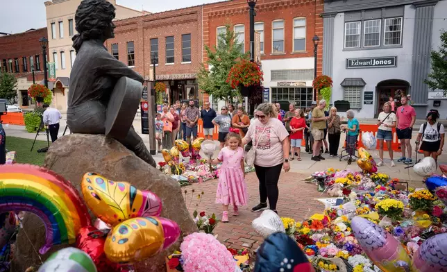 People lay flower at a memorial honoring Dolly Parton in Sevierville, Tenn., Wednesday, Aug. 26, 2026. (AP Photo/Camden Hall)