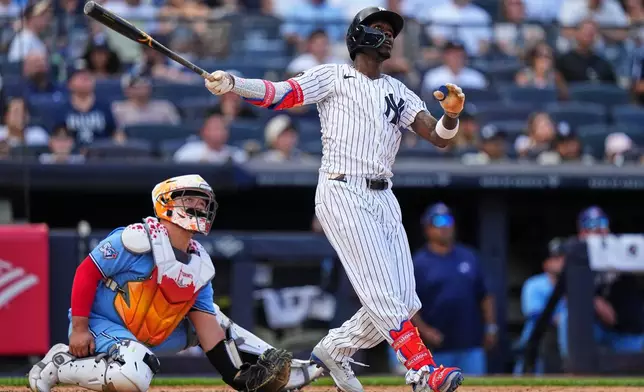 Toronto Blue Jays catcher Alejandro Kirk, left, watches as New York Yankees' Jazz Chisholm Jr. hits a two-run home run during the seventh inning of a baseball game Sunday, Aug. 23, 2026, in New York. (AP Photo/Frank Franklin II)