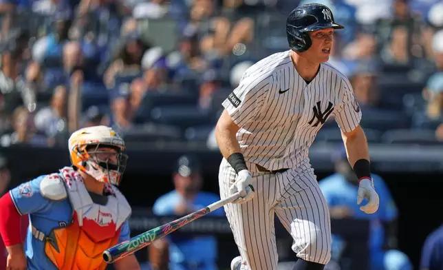 Toronto Blue Jays catcher Alejandro Kirk, left, watches as New York Yankees' Ben Rice follows through on a two-run single during the sixth inning of a baseball game Sunday, Aug. 23, 2026, in New York. (AP Photo/Frank Franklin II)