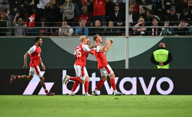 Hallescher's Vin Kastull, right, celebrates scoring with teammates during the German soccer cup match between Hallescher FC and FC Schalke 04 in Halle, Germany, Monday Aug. 24, 2026. (Hendrik Schmidt/dpa via AP)