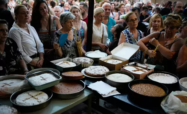 Pilgrims wait in line to have their Fanouropites, orange-flavored cakes, blessed at the Church of St. Fanourios in Athens, Wednesday, Aug. 26, 2026. (AP Photo/Thanassis Stavrakis)