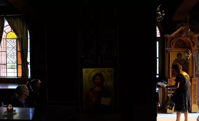 Pilgrims wait to have their Fanouropites, orange-flavored cakes, blessed at the Church of St. Fanourios in Athens, Tuesday, Aug. 25, 2026. (AP Photo/Thanassis Stavrakis)