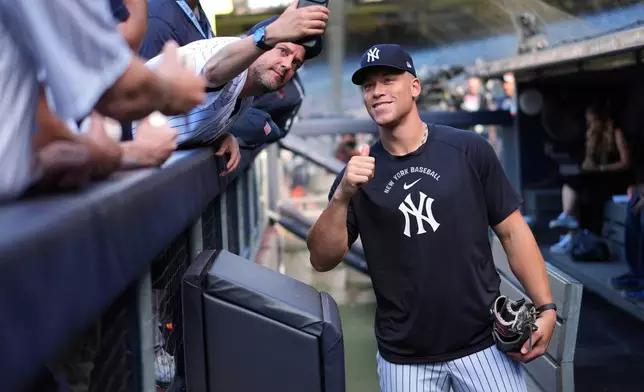 New York Yankees' Aaron Judge poses for a photo with a fan before a baseball game against the Houston Astros Tuesday, Aug. 25, 2026, in New York. (AP Photo/Frank Franklin II)