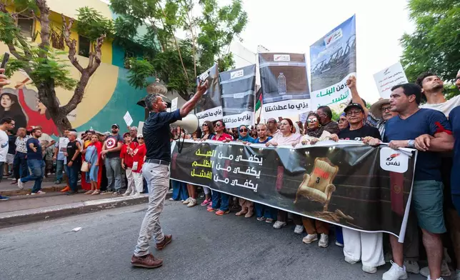 People take part in a protest against rising prices, declining purchasing power and shortages of basic goods in Tunis, Tunisia, Thursday, Aug. 20, 2026. Banner in Arabic reads "Enough injustice, enough failure." (AP Photo/Ons Abid)