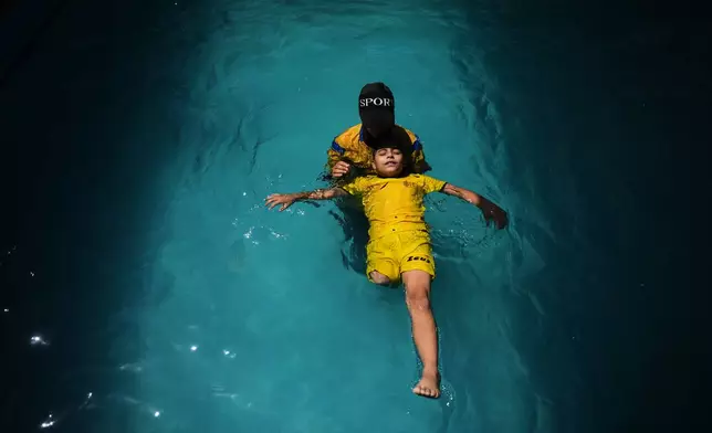 Palestinian girl Miral al-Babli, who lost a leg after being injured during the war between Israel and Hamas, receives swimming training from the Heal Palestine organization at a pool in Khan Younis, Gaza Strip, Thursday, Aug. 20, 2026. (AP Photo/Abdel Kareem Hana)