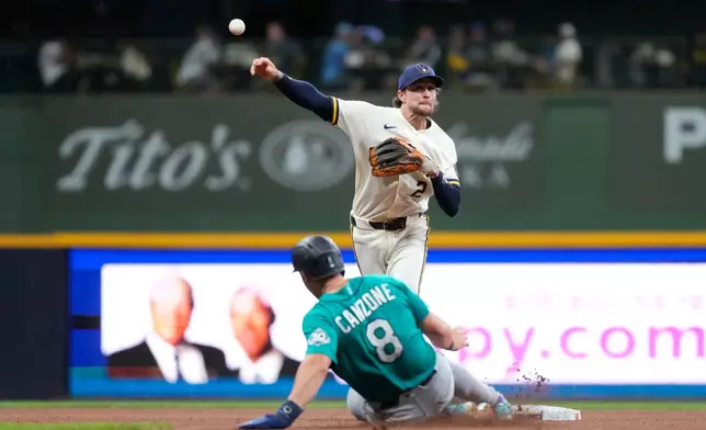 Milwaukee Brewers' Brice Turang (2) throws to first base after tagging Seattle Mariners' Dominic Canzone (8) out at second during the fourth inning of a baseball game Wednesday, Aug. 19, 2026, in Milwaukee. (AP Photo/Aaron Gash)