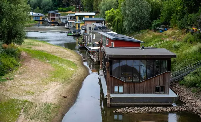 Houseboats sit in low water on the Waal river in Nijmegen, Netherlands, Thursday, July 30, 2026, due to drought conditions. (AP Photo/Patrick Post)