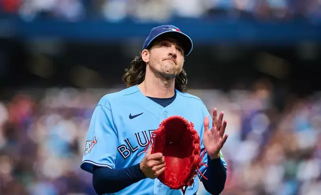 Toronto Blue Jays' Kevin Gausman applauds to the crowd as he is taken out by manager John Schneider during the sixth inning of a baseball game against the St. Louis Cardinals in Toronto, Saturday, Aug. 1, 2026. (Sammy Kogan/The Canadian Press via AP)