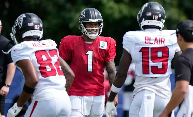 Atlanta Falcons quarterback Tua Tagovailoa (1) cuts between wide receiver Antwane Wells Jr. (82) and wide receiver Chris Blair (19) during a joint practice with the Indianapolis Colts at the team's NFL football training camp in Westfield, Ind., Wednesday, Aug. 19, 2026. (AP Photo/Michael Conroy)