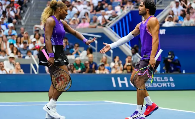 Serena Williams, of the United States, and Carlos Alcaraz, of Spain, high-five during a mixed doubles match at the U.S. Open tennis championships, Tuesday, Aug. 25, 2026, in New York. (AP Photo/Yuki Iwamura)