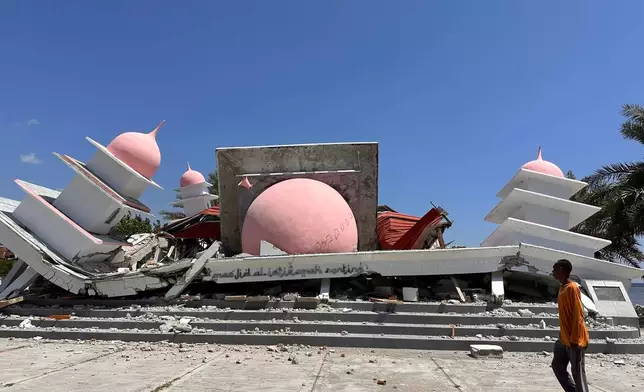 A man walks past a mosque collapsed during an earthquake in Lamba Leda, East Nusa Tenggara province, Indonesia, Tuesday, Aug. 18, 2026. (AP Photo/Firdia Lisnawati)