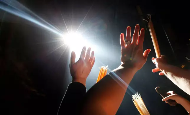 FILE - Christian Orthodox pilgrims raise their hands towards a beam of light in front of the Edicule at the Church of the Holy Sepulcher during the ceremony of the Holy Fire in Jerusalem's Old City, Saturday, April 18, 2009. (AP Photo/Kevin Frayer, File)