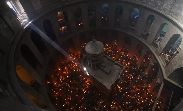 FILE - Christian Orthodox pilgrims hold up candles during the Holy Fire ceremony, at the Church of the Holy Sepulcher in the Old City of Jerusalem, Saturday, April 11, 2026. (AP Photo/Mahmoud Illean, File)