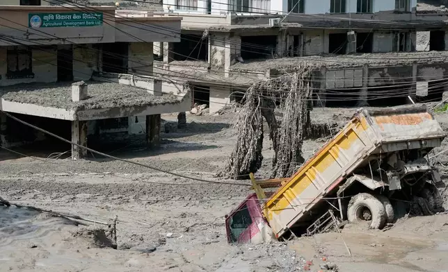 Damaged houses and vehicles are seen in the aftermath of flash floods along the Trishuli River in Nepal's Nuwakot district, Wednesday, Aug. 26, 2026. (AP Photo/Niranjan Shrestha)