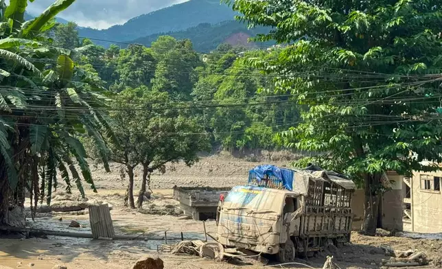 Damaged houses and vehicles are seen in the aftermath of flash floods along the Trishuli River in Nepal's Nuwakot district, Wednesday, Aug. 26, 2026. (AP Photo/Niranjan Shrestha)