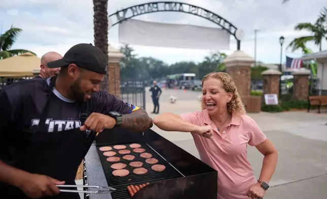 Rep. Debbie Wasserman Schultz, D-Fla., greets a man tending to a grill as she visits a National Night Out community event while campaigning for Florida's 20th congressional district, in Plantation, Fla., Tuesday, Aug. 4, 2026. (AP Photo/Rebecca Blackwell).