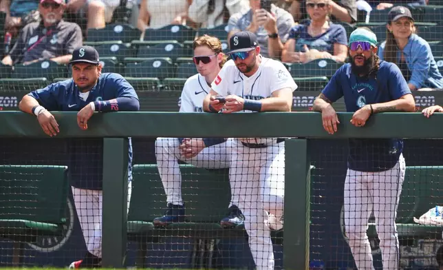 From left, Seattle Mariners' Josh Naylor, Colt Emerson, Cal Raleigh and J.P. Crawford watch from the dugout railing during the first inning of a baseball game against the Detroit Tigers, Thursday, Aug. 6, 2026, in Seattle. (AP Photo/Lindsey Wasson)