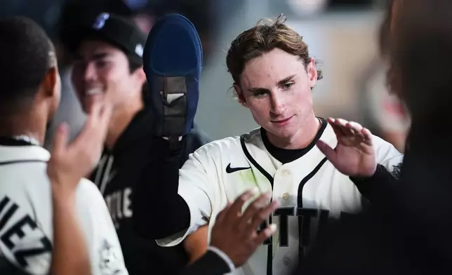 Seattle Mariners' Colt Emerson is greeted in the dugout after scoring on an RBI single against the Minnesota Twins during the sixth inning of a baseball game, Sunday, Aug. 2, 2026, in Seattle. (AP Photo/Lindsey Wasson)
