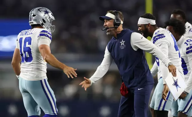 Dallas Cowboys head coach Brian Schottenheimer celebrates with quarterback Sam Howell (16) after a two-point conversion against the New Orleans Saints during the second half of a preseason NFL football game, in Arlington, Texas, Friday, Aug. 28, 2026. (AP Photo/Gareth Patterson)