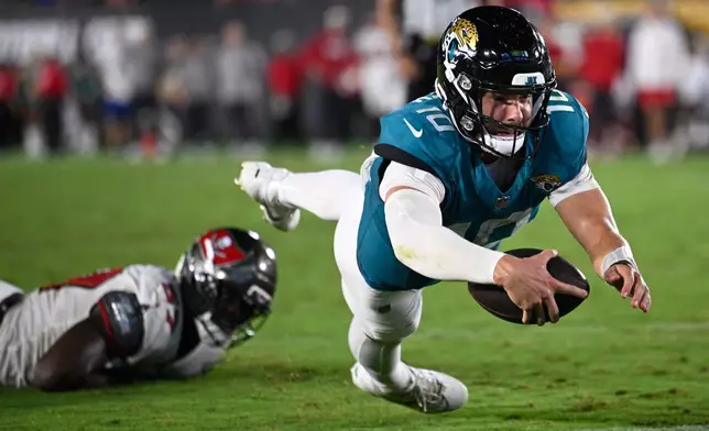 Jacksonville Jaguars quarterback Carter Bradley (10) dives into the end zone for a two-point conversion during the second half of an NFL preseason football game against the Tampa Bay Buccaneers, Friday, Aug. 28, 2026, in Jacksonville, Fla. (AP Photo/Phelan M. Ebenhack)