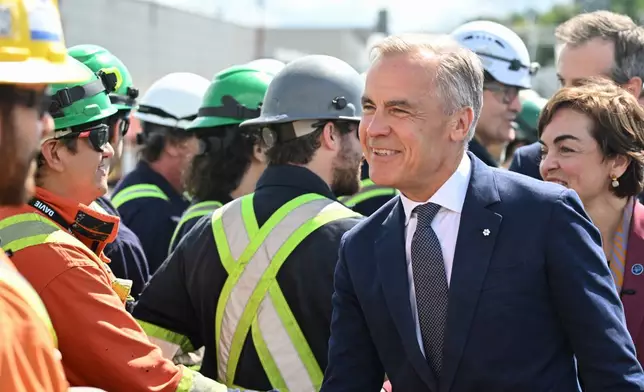Canadian Prime Minister Mark Carney meets workers at the Davie shipyard in Levis, Monday, Aug. 24, 2026. (Jacques Boissinot/The Canadian Press via AP)