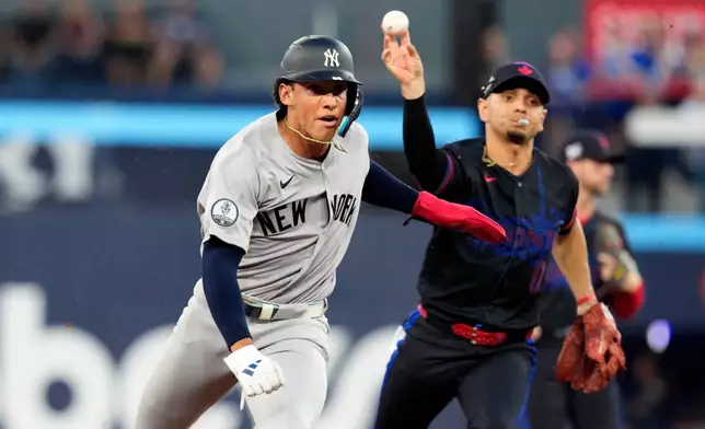 New York Yankees shortstop George Lombard Jr. (96) gets caught in a rundown as Toronto Blue Jays shortstop Andrés Giménez (0) throws to third for the out during the first inning of a baseball game in Toronto, Friday, Aug. 14, 2026. (Chris Young/The Canadian Press via AP)