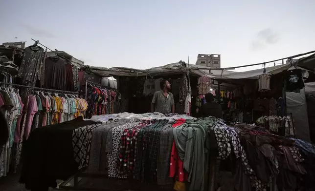 A Palestinian vendor offers clothes for sale in Gaza City, Monday, Aug. 17, 2026. (AP Photo/Jehad Alshrafi)