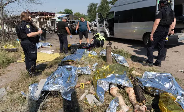 EDS NOTE: GRAPHIC CONTENT - Police officers inspect bodies of victims of a Russian air attack which killed at least ten civilians in Pechenihy, Kharkiv region, Ukraine, Tuesday, Aug. 18, 2026. (AP Photo/Andrii Marienko)