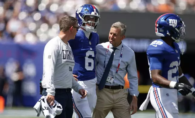 New York Giants quarterback Jaxson Dart (6) is helped off the field after being sacked by Minnesota Vikings' Jay Ward during the first half of a preseason NFL football game Saturday, Aug. 15, 2026, in East Rutherford, N.J. (AP Photo/Adam Hunger)