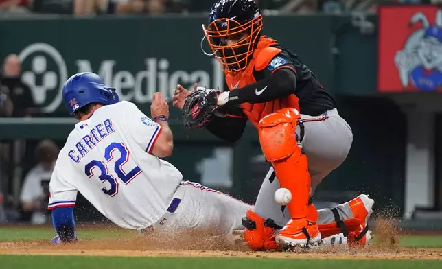 Texas Rangers' Evan Carter (32) scores against Baltimore Orioles catcher Carlos Narváez, right, during the second inning of a baseball game, Saturday, Aug. 8, 2026, in Arlington, Texas. (AP Photo/LM Otero)
