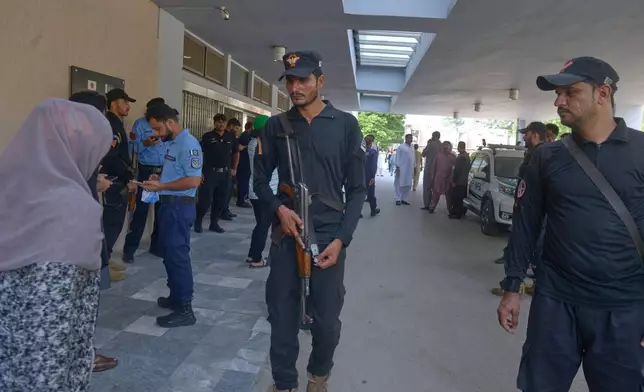 Police officers stand guard outside a nursery following a fire at a hospital in Islamabad, Pakistan, Wednesday, Aug. 26, 2026. (AP Photo/M.A. Sheikh)